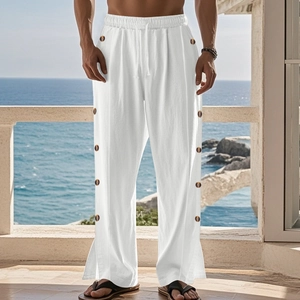 Detail of white linen pants featuring side wooden buttons and a split hem design