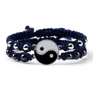 Detailed view of woven blue bracelets with Yin Yang charms and metallic beads