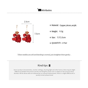 Detailed view of red acrylic petal tassel earrings with zircon studs and gold finish