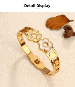 Macro detail of gold flower bangle with crystal inlay and hollow floral patterns