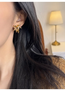 Close-up of 18K gold plated flower earrings with tiger eye stone and pearl accents