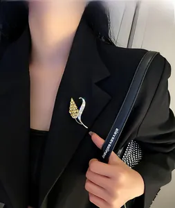 Gros plan d'une broche en forme d'épi de blé sertie de diamants sur un blazer noir