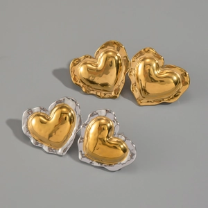 Detail of heart stud earrings with irregular wavy edges in gold and silver finish