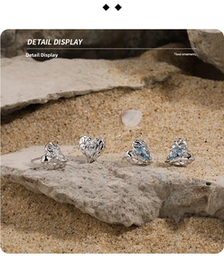 Detailed macro view of S925 silver heart studs with lava texture and pear-cut gemstones