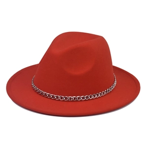 Macro detail of red wool fedora hat featuring a chunky silver metal chain decoration