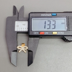 Macro shot of a butterfly pendant with crystals measured by a digital caliper for sizing