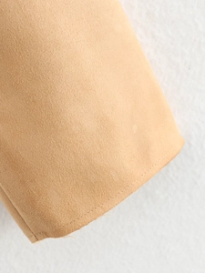 Détail macro du daim camel montrant la texture douce et les lignes de couture précises