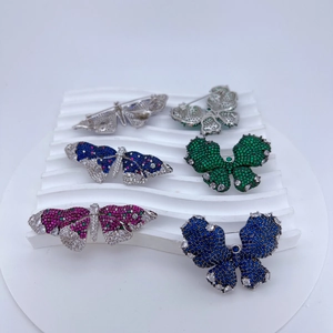 Gros plan de broches papillon avec oxydes de zirconium et base en alliage argenté
