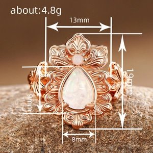 Vintage rose gold floral ring featuring pear-shaped white opal and bohemian carvings