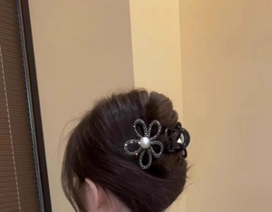 Detail of sunflower hair claw clip with silver rhinestones and pearl on hair