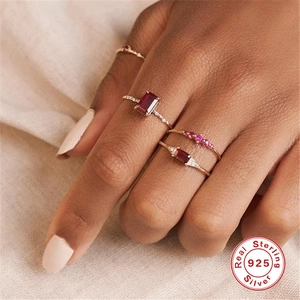 Detail of 925 sterling silver gold plated rings with red rubies on female hand