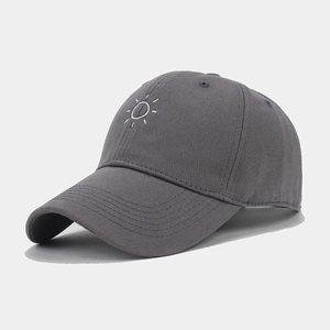Detail shot of white sun embroidery on dark grey cotton twill baseball cap