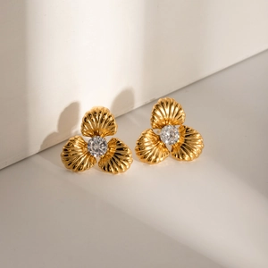 Detail of 18k gold plated clover earrings with shell texture and cz center stone