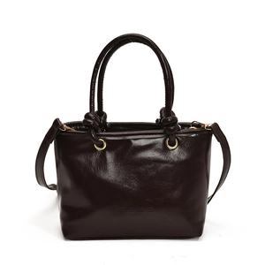 Classic dark brown bucket bag in glossy leather with knotted handles and a long shoulder strap