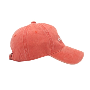 Detail view of washed cotton baseball cap featuring 'bad' embroidery and metal buckle
