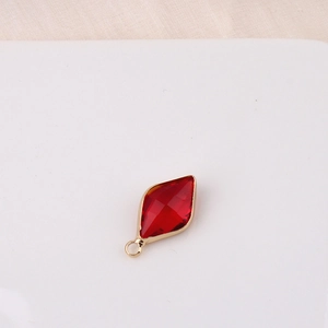 Detail of a red rhombus-cut crystal pendant with a gold-plated bezel for jewelry DIY