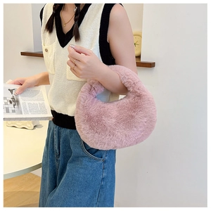 Detail of pink plush faux fur handbag texture and semi-circular design on model arm