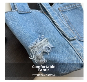 Detail showing distressed denim fabric and frayed hole texture on the bucket bag