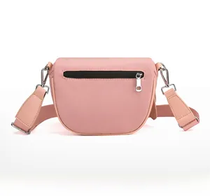 Close-up of the back zipper pocket and durable nylon texture on pink crossbody bag