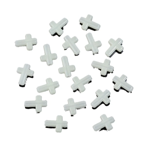 Luminous plastic cross beads for DIY jewelry making, scattered on white background