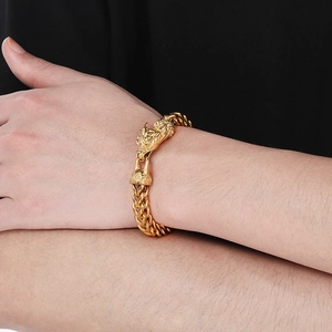 Nahaufnahme eines maskulinen goldenen Drachenkopf-Armbands am Handgelenk eines Mannes