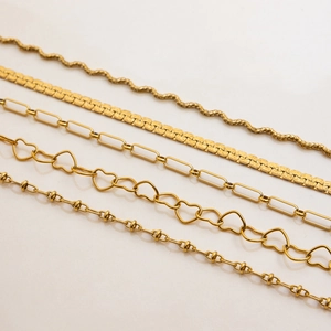 Flat lay of five gold stainless steel necklace chain styles with diverse link designs
