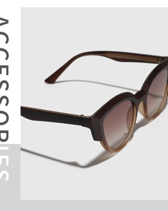 Detail of amber tortoiseshell sunglasses frame showing lens size and temple engraving