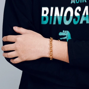 Close-up of a stylish gold titanium steel O-chain bracelet worn on a model's wrist