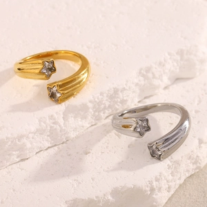 Detail of gold and silver open rings with star charms and sparkling zircons