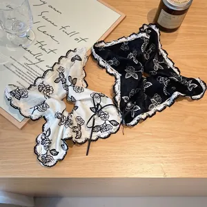 Vintage rose pattern scrunchies with lace trim and elegant pearl bow accents on wood table