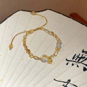 Detail view of yellow citrine and white crystal beaded bracelet with lotus pod charm