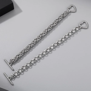 Détail d'un bracelet en acier titane avec fermoir OT en cœur et maillons de chaîne tissés