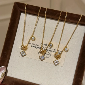 Detail of luxury gold clover and sparkling diamond pendants on fine chain necklaces