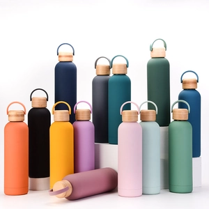 Close-up of colorful matte insulated bottles with bamboo lids on white display stands