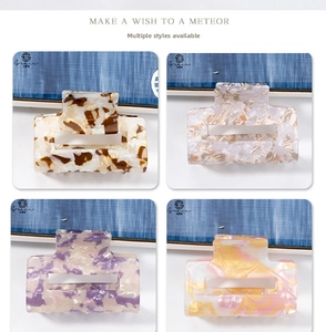 Detailed view of four colorful marble pattern square hair claws in a 2x2 grid layout