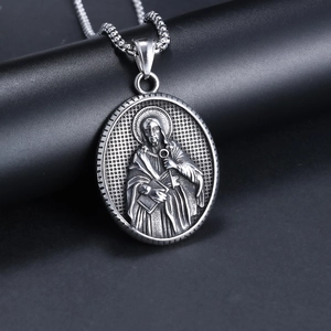 Vintage oval religious portrait pendant with metal chain on a black stand