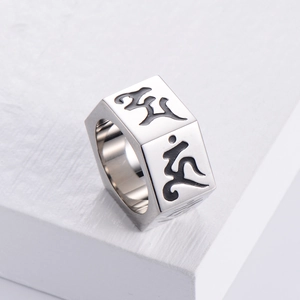 Hexagon nut shaped stainless steel ring with Sanskrit engraving on white wood block