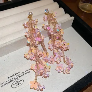 Elegant floral tassel earrings with peach crystals and shimmering iridescent petals