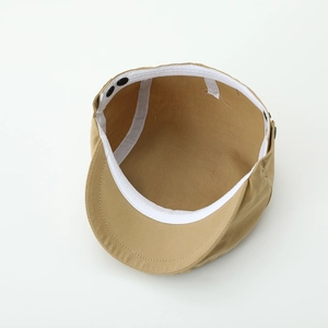 Detail of the inner sweatband and black adjustable buckle on this kids' beige beret cap