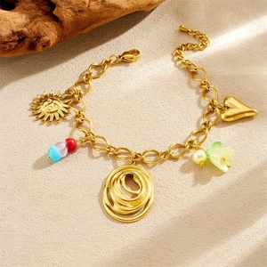 Golden chain bracelet with acrylic lily and heart charms on a beige textured background