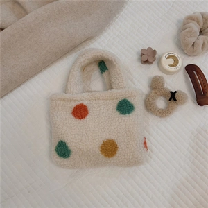 Close-up of fuzzy polka dot tote bag with colorful spots on soft lamb wool texture