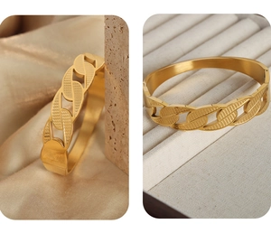 Macro detail of gold-plated chain link texture on a stainless steel open cuff bracelet