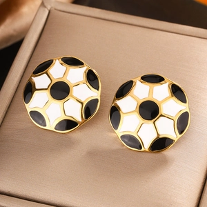 Macro detail of 18K gold plated enamel flower earrings in black and white finish
