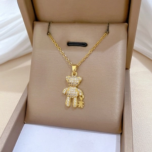 Detailed view of gold bear pendant necklace with white zircons in a premium jewelry box