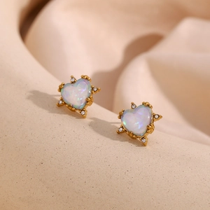Detail of heart-shaped gold earrings with iridescent white opal stones and micro-inlay