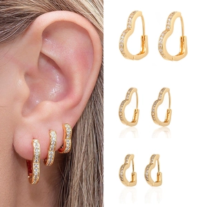 Detailed view of three sizes of gold heart hoop earrings with pavé zircon setting