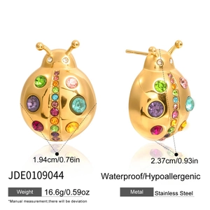 Macro detail of ladybug earrings in gold stainless steel with colorful rhinestones