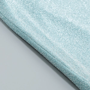 Macro shot of light blue glitter fabric detail with shimmering metallic texture and weave