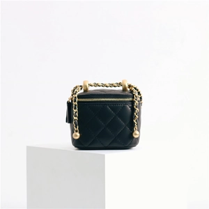 Macro shot of black quilted sheepskin leather vanity bag with gold chain strap detail