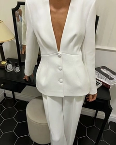 Detailed close-up of a white deep V-neck blazer with waist design and three buttons